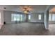Spacious living room featuring new carpeting, abundant natural light, and a ceiling fan at 804 Wildwood Cir, Port Orange, FL 32127