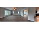 Open-concept living room filled with natural light and featuring stylish ceiling fan and new carpeting at 804 Wildwood Cir, Port Orange, FL 32127