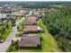 An aerial perspective of houses with terracotta roofs alongside a winding street and lush trees at 819 San Raphael St, Kissimmee, FL 34759