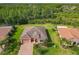 Stunning aerial view of a beautiful home with lush landscaping and a serene wooded backdrop at 819 San Raphael St, Kissimmee, FL 34759