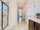 Hallway view to a bathroom showcasing a glass-enclosed shower and vanity, leading to a bright living area beyond at 819 San Raphael St, Kissimmee, FL 34759