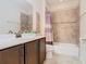 Well-maintained bathroom features a shower-tub combo, tile surround, and modern vanity at 819 San Raphael St, Kissimmee, FL 34759