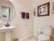 Cozy powder room features a pedestal sink, framed mirror, and neutral color scheme at 819 San Raphael St, Kissimmee, FL 34759