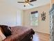 Bright bedroom featuring wood floors, a ceiling fan, and a large window overlooking the yard at 819 San Raphael St, Kissimmee, FL 34759