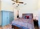 Well-lit bedroom with wood floors, ceiling fan, and stylish blue dresser at 819 San Raphael St, Kissimmee, FL 34759