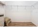 Minimalist closet includes wire shelving, complemented by wood-look vinyl floors and an adjacent wicker storage unit at 819 San Raphael St, Kissimmee, FL 34759
