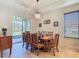 Bright dining room featuring a wooden table set, chandelier lighting, and sliding glass doors to the outdoor patio at 819 San Raphael St, Kissimmee, FL 34759