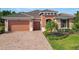 Charming single-story home featuring a brick driveway, two-car garage, and tile roof at 819 San Raphael St, Kissimmee, FL 34759
