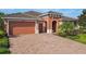 Charming single-story home with a brick driveway, two-car garage, and covered front entrance at 819 San Raphael St, Kissimmee, FL 34759