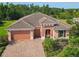 Charming single-story home featuring a brick driveway, two-car garage, tile roof and manicured landscaping at 819 San Raphael St, Kissimmee, FL 34759