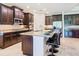 The updated kitchen features stainless steel appliances, a granite island with barstool seating, and rich, dark wood cabinetry at 819 San Raphael St, Kissimmee, FL 34759