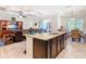 Open-concept kitchen island features granite countertops, stainless steel appliances, and seamless access to the living and dining areas at 819 San Raphael St, Kissimmee, FL 34759