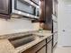 Gourmet kitchen boasts stainless steel appliances, granite countertops, custom cabinets and a smooth cooktop at 819 San Raphael St, Kissimmee, FL 34759