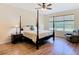 Bright main bedroom features a four-poster bed, hardwood floors, and relaxing reading area at 819 San Raphael St, Kissimmee, FL 34759