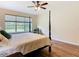 Spacious main bedroom with four-poster bed, wood floors, and a large window at 819 San Raphael St, Kissimmee, FL 34759