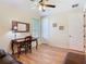 The home office features wood flooring, a desk, a ceiling fan and natural light from a window with blinds at 819 San Raphael St, Kissimmee, FL 34759