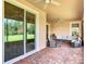 Covered brick patio with comfortable outdoor seating, ceiling fans, and a view to the backyard at 819 San Raphael St, Kissimmee, FL 34759