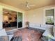 Brick patio with comfortable seating, ceiling fan, and open access to the living room at 819 San Raphael St, Kissimmee, FL 34759