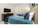 Comfortable bedroom featuring stylish blue bedding, a television and matching wooden dresser at 9038 Pelican Cove Trce, Kissimmee, FL 34747