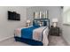 Well-lit bedroom with a comfortable bed, contemporary lamps, and wall-mounted television for entertainment at 9038 Pelican Cove Trce, Kissimmee, FL 34747