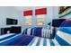 Charming bedroom with twin beds, a dresser, and nautical-themed decor, creating a comfortable space at 9038 Pelican Cove Trce, Kissimmee, FL 34747