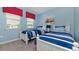Cozy bedroom with twin beds, blue walls, and nautical-themed decor, creating a relaxing atmosphere at 9038 Pelican Cove Trce, Kissimmee, FL 34747