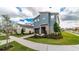 Modern two-story home featuring a stone facade, well-manicured landscaping, and an attached garage at 9038 Pelican Cove Trce, Kissimmee, FL 34747