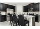 Modern kitchen with stainless steel appliances, granite countertops, and black cabinets at 9038 Pelican Cove Trce, Kissimmee, FL 34747