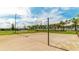 Community volleyball court featuring groomed sand and palm trees, providing an ideal space for outdoor recreation and fun at 9038 Pelican Cove Trce, Kissimmee, FL 34747