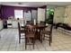 Dining room with round table and tile flooring adjacent to kitchen with white appliances and purple accent wall at 98 Orange Park Blvd, Lake Wales, FL 33898