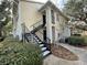 Two-story townhome featuring black door and stairs with a cozy, landscaped entrance at 1027 S Hiawassee Rd # 2323, Orlando, FL 32835