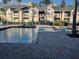 Community pool with blue water, brick surround and palm trees in a multi-story condo complex at 1027 S Hiawassee Rd # 2323, Orlando, FL 32835