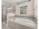 Spa-like bathroom featuring a soaking tub and glass-enclosed shower at 11843 Fiction Ave, Orlando, FL 32832