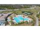 Aerial view of the resort-style community pool and tennis courts surrounded by landscaping and trees at 11843 Fiction Ave, Orlando, FL 32832