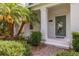 Charming front porch with well-manicured landscaping, a green door, and brick walkway at 11843 Fiction Ave, Orlando, FL 32832