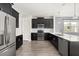 Modern kitchen featuring dark cabinetry, stainless steel appliances, and a stylish breakfast bar at 11843 Fiction Ave, Orlando, FL 32832