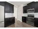 Well-equipped kitchen with stainless steel appliances, dark cabinets, and light backsplash at 11843 Fiction Ave, Orlando, FL 32832