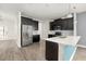 Modern kitchen featuring dark cabinetry, stainless steel appliances, and a stylish breakfast bar at 11843 Fiction Ave, Orlando, FL 32832