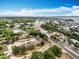 Aerial view of a lakeside community with well-maintained buildings, lush landscaping, and nearby roads at 12539 Orangewood Ct, Tavares, FL 32778
