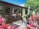 Back patio with outdoor seating area and views of mature landscaping at 12539 Orangewood Ct, Tavares, FL 32778