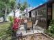 Home's backyard featuring patio seating area, beautiful landscaping, and mature trees at 12539 Orangewood Ct, Tavares, FL 32778