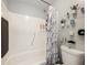 Bright bathroom featuring a shower/tub combination with stylish curtain and convenient shelving at 12539 Orangewood Ct, Tavares, FL 32778