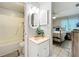 Bathroom adjacent to bedroom featuring a shower with grab bar, vanity, mirror, and natural light at 12539 Orangewood Ct, Tavares, FL 32778
