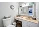 Bathroom featuring a sink vanity with a large mirror and a toilet at 12539 Orangewood Ct, Tavares, FL 32778