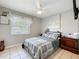Bedroom with a plaid bedspread, ceiling fan, and a window providing natural light at 12539 Orangewood Ct, Tavares, FL 32778