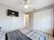 Bedroom with tile floors, ceiling fan, television on wall, and closet space at 12539 Orangewood Ct, Tavares, FL 32778