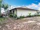 Exterior view of house, showcasing the back patio and flourishing landscaping at 12539 Orangewood Ct, Tavares, FL 32778