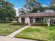 Charming home with a landscaped yard, flower beds, and beautiful walkway at 12539 Orangewood Ct, Tavares, FL 32778