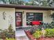Charming home with a landscaped yard, flower beds, and a bright red bench at 12539 Orangewood Ct, Tavares, FL 32778