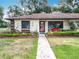 Charming home with a landscaped yard, flower beds, and beautiful walkway at 12539 Orangewood Ct, Tavares, FL 32778
